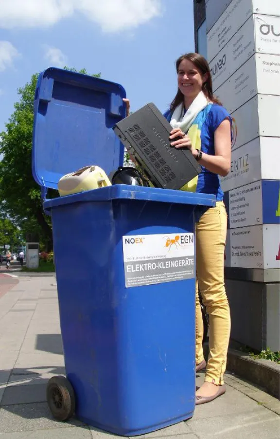 NOVENTIZ-Mitarbeiterin entsorgt ein altes Elektrogerät am Tag der Umwelt.