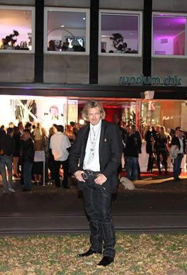 Stefan Blumtritt. im Hintergrund der Menschenauflauf vor seinem neuen Salon auf zwei Etagen