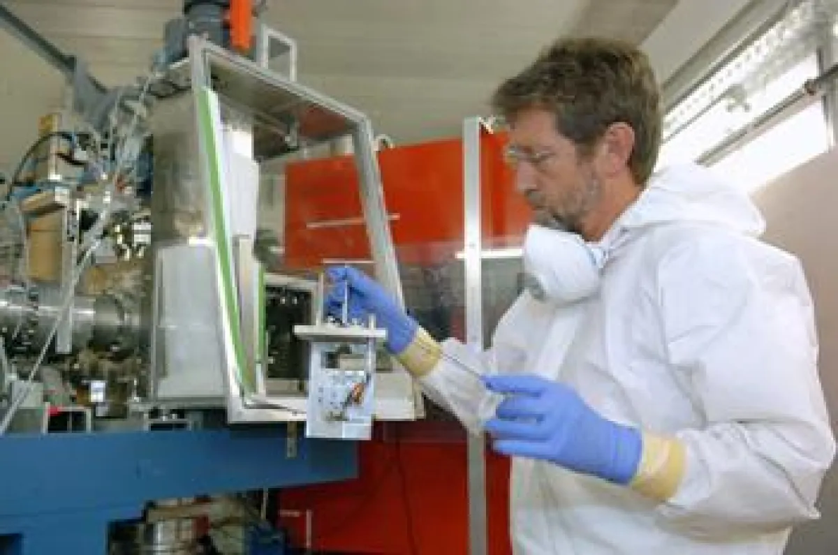 Dr. Matthias Schädel, Leiter der GSI-Kernchemie, bei Arbeiten an der Bestrahlungskammer. Links von ihm ein Teil des TASCA-Separators.