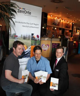 Bild: Disc-Golf Broschüre der ZeitOrte von Weltmeister und Filmcrew vorgestellt