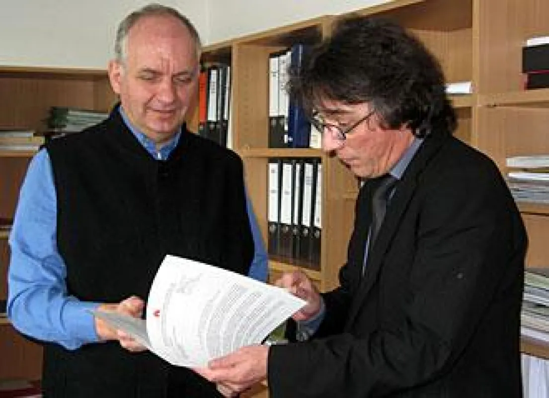 Ulrich Vieluf, Staatsrat der Behörde für Schule und Berufsbildung, überreicht dem Schulgründer Axel Beyer die Unterlagen für die Primarschule / Grundschule und das Gymnasium.
