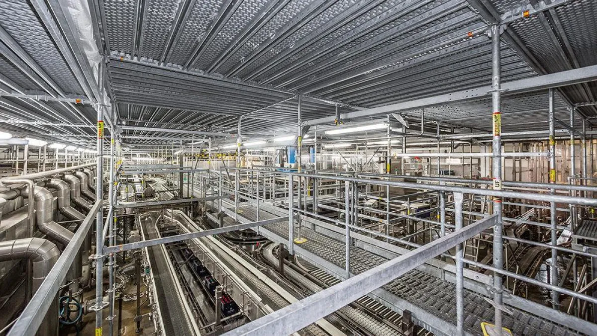 Die PERI UP Gerüstebene schottete die Produktionslinie der Abfüllanlage von der Baumaßnahme ab.