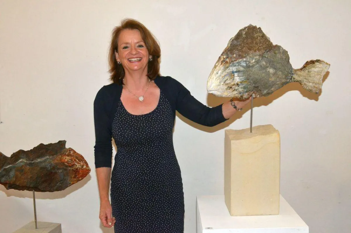Anne Huster präsentiert zwei Fische, die aus der Grundform der Steine entstanden sind.