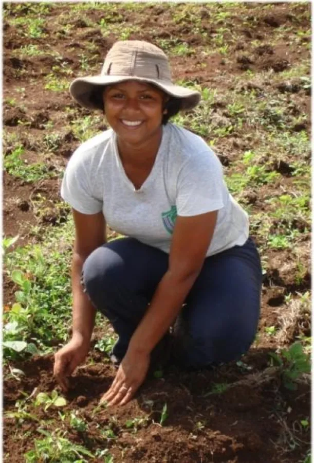 Frau pflanzt Teakbaum-Setzling