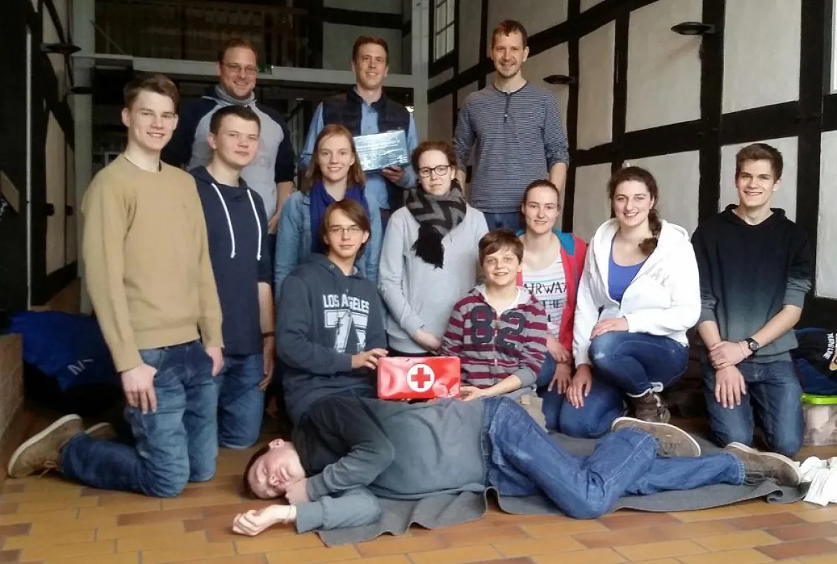 Apotheker Björn Schmidt überreicht Teamern und Treffleitung einen DIN-normierten 1.-Hilfe-Kasten.