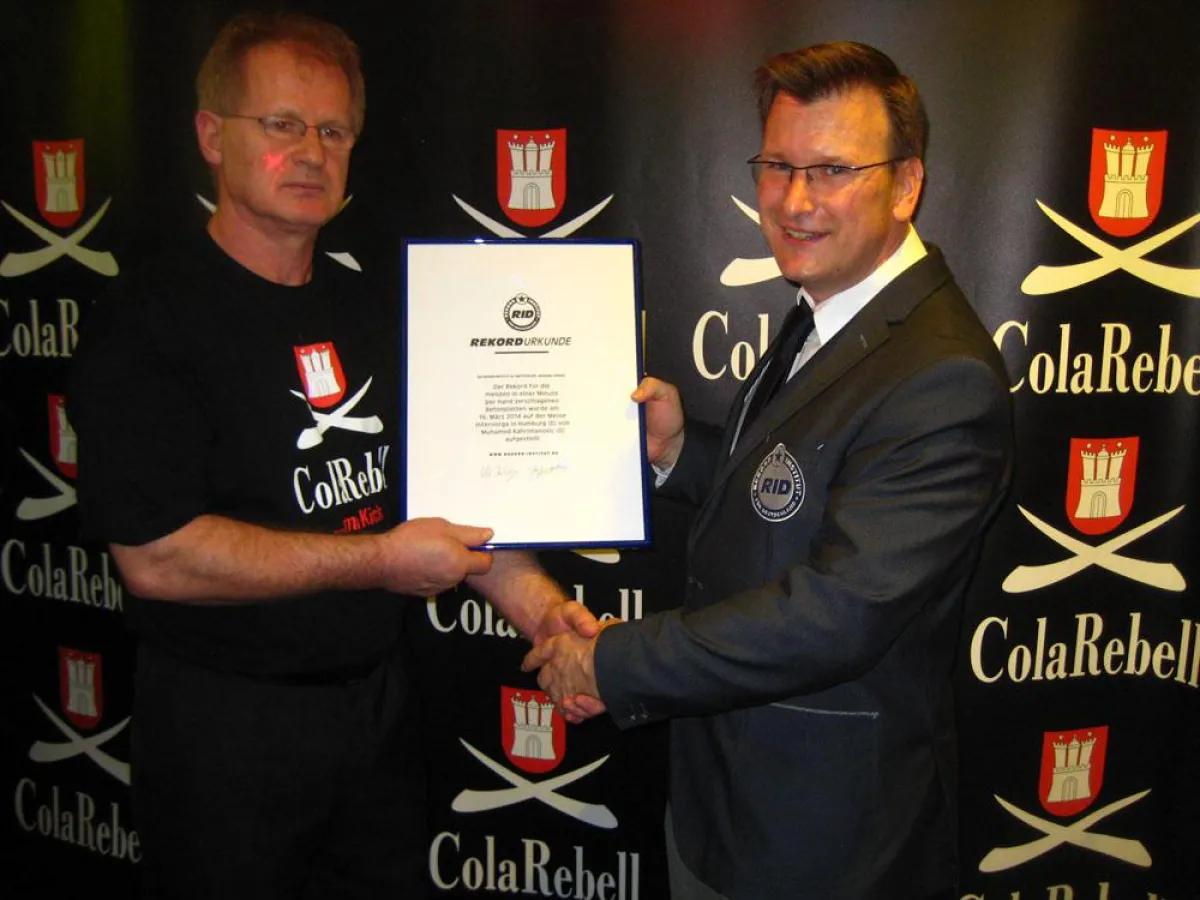 Rekordrichter Olaf Kuchenbecker überreicht »Hammerhand« die RID-Rekordurkunde  auf der Internorga.