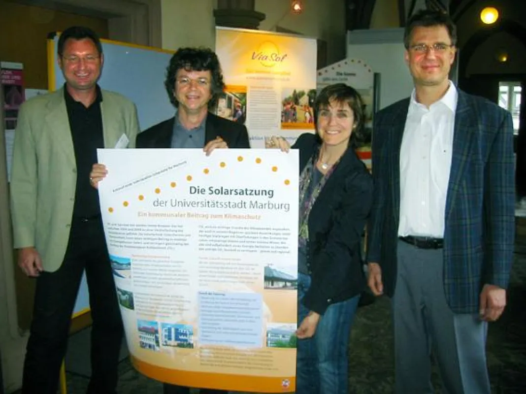 Gemeinsam mit den Vertretern der Marburger Sonneninitiative, Volker Klös (links) und Christian Quast (rechts), überreichte Dr. Astrid Wetzel von der Agentur