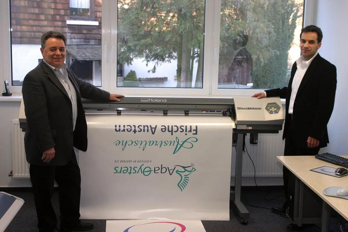 Firmengründer Steffen Leinberger (rechts) und sein Vater vor einem Großformatdrucker in den neuen Firmenräumen