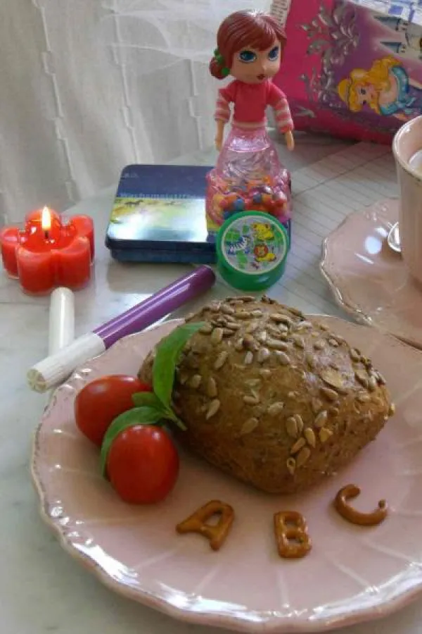 Ein liebevoll gedeckter Frühstückstisch - dekoriert mit bunten Blütenlichten mit dem RAL-Gütezeichen - lassen Klein und Groß den ersten Schultag fröhlich beginnen. Foto: Gütegemeinschaft Kerzen