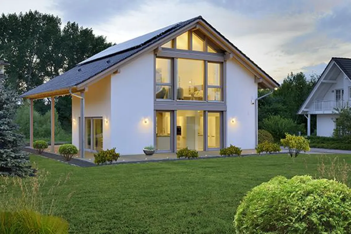 Außenansicht: Sichtbare Fachwerkelemente und bodentiefe Fensterflächen verbinden Landhausarchitektur