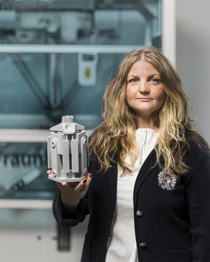 Dr. Simina Fulga-Beising mit einem 3D-gedruckten pneumatischen Roboter-Auslenk-System zum Entgraten. (Quelle: Fraunhofer IPA, Foto: Rainer Bez)
