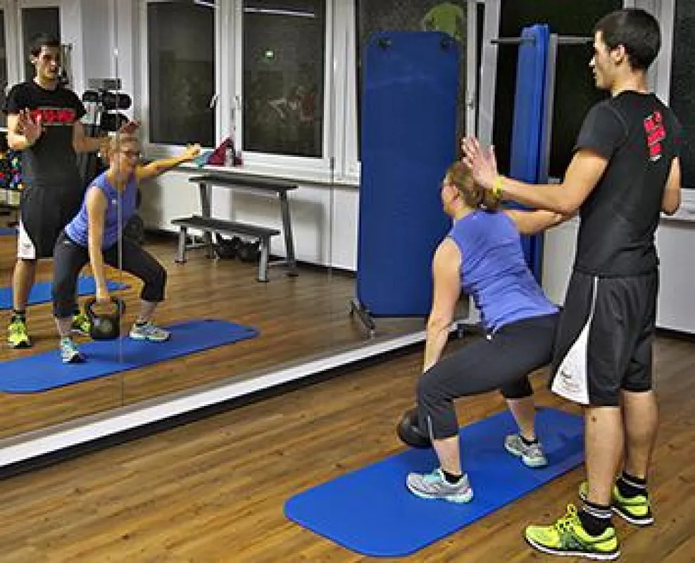 Rouven Mersni zeigt einer Teilnehmerin, worauf es beim Kettlebell-Training ankommt.