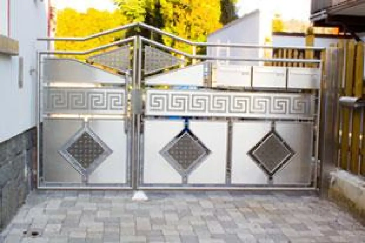 Hoftor aus Edelstahl, mit integrierten Briefkästen und individuellem Motiv als Schleiftechnik