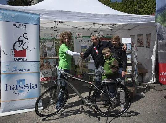 Bild: Glücklicher Gewinner erhält hassia-Trekkingfahrrad