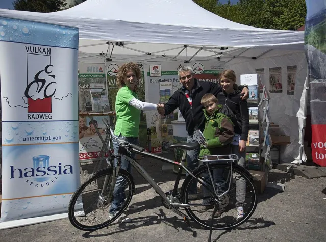 Bild: Glücklicher Gewinner erhält hassia-Trekkingfahrrad
