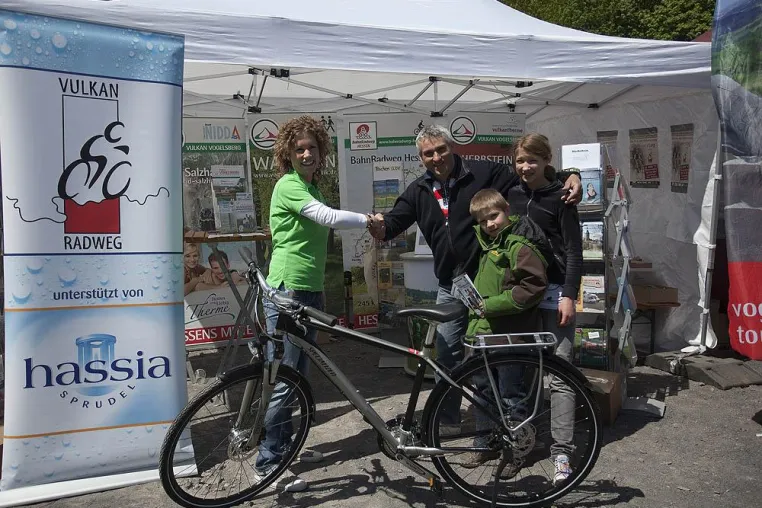 Bild: Glücklicher Gewinner erhält hassia-Trekkingfahrrad