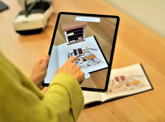 Bild: Wenn zwei Welten ineinanderfließen – das analoge Buch und die erweiterte digitale Welt