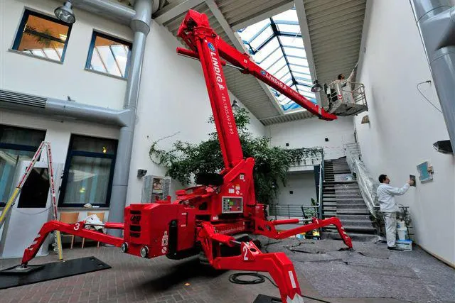 Bild: Mit Farbeimer und Rolle in den Arbeitsbühnenkorb: Schnelle Malerarbeiten mit Raupenbühne von System Lift