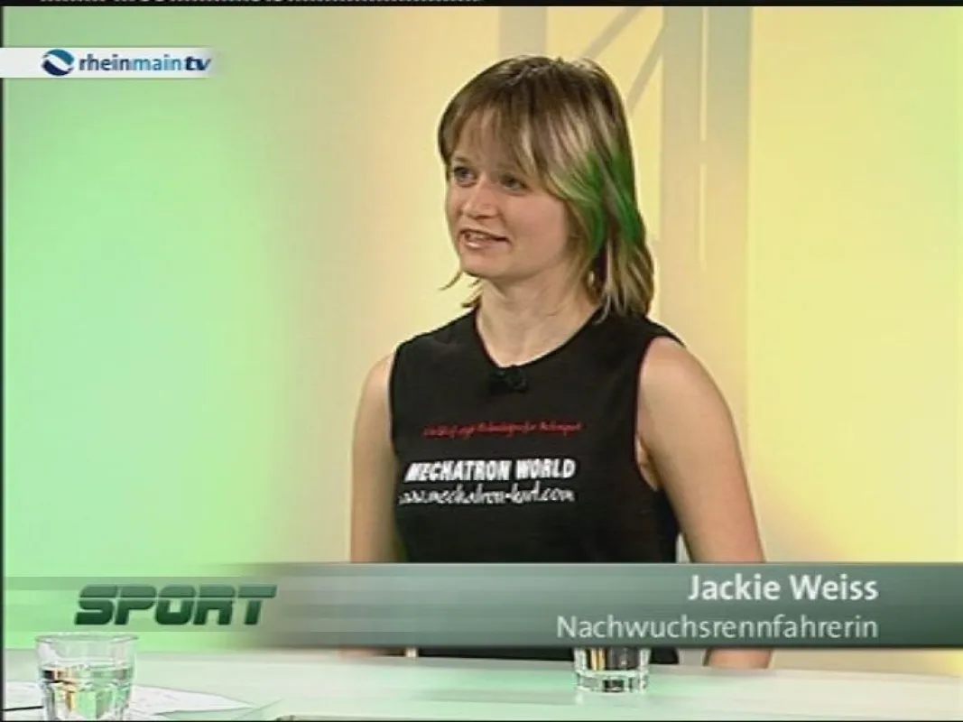 Jackie Weiss im Sportstudio vom RheinMain TV: In 2008 werde ich in der neuen ADAC Formel Masters unterwegs sein. Als Redaktions Volontärin werde ich auch im Speed-Magazin darüber berichten