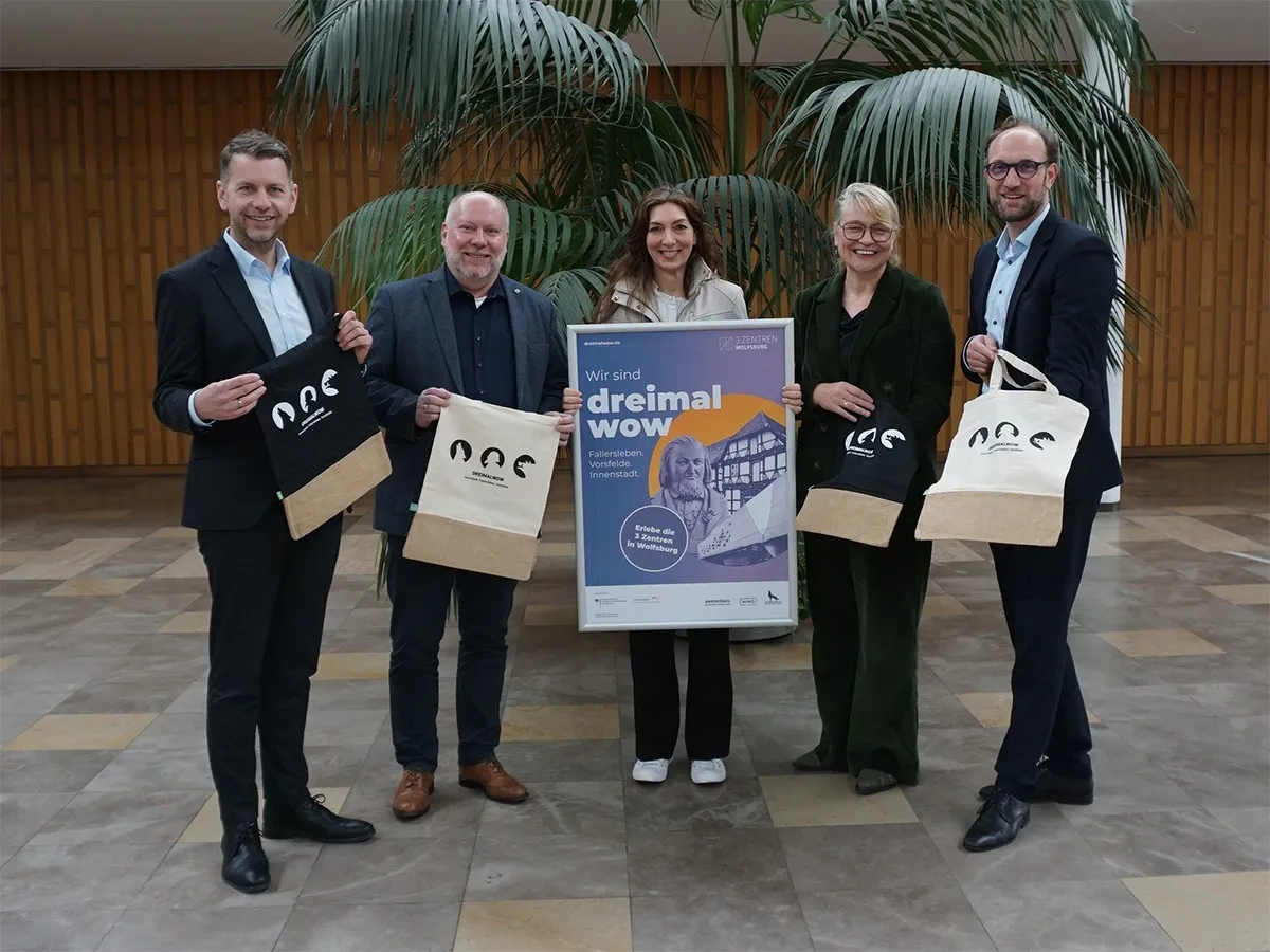 Die Beteiligten präsentieren die limitierten Beutel der „dreimal wow“-Imagekampagne.  (© WMG Wolfsburg)