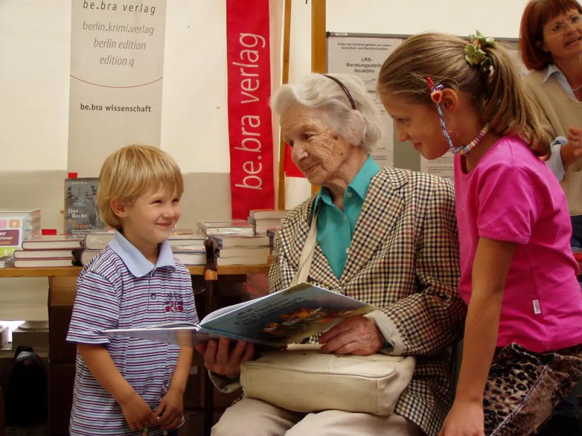 Lesen verbindet: Die älteste Besucherin Lieselotte B. (91) ließt ein Kinderbuch für Kimerly (8) und Arwed (3) vor.