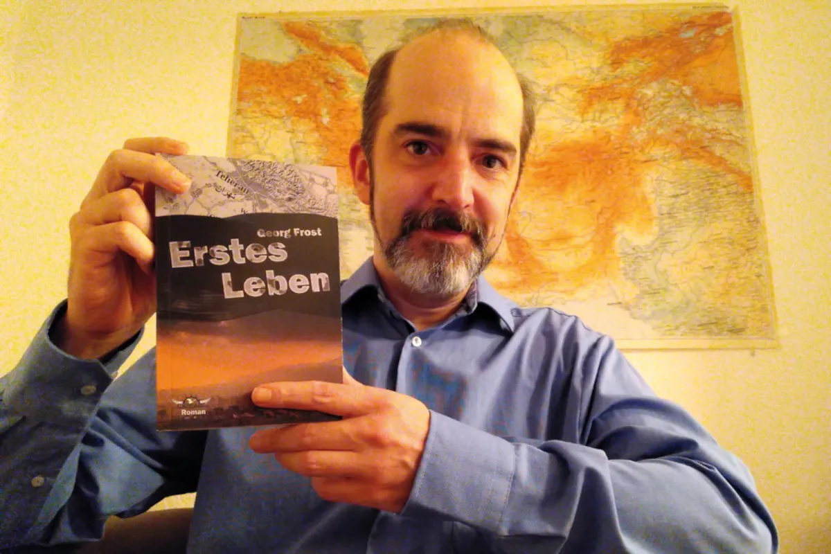 Georg Frost mit seinem Roman, einer Liebesgeschichte im Teheran des Jahrs 2005. (© catware.net Verlag)