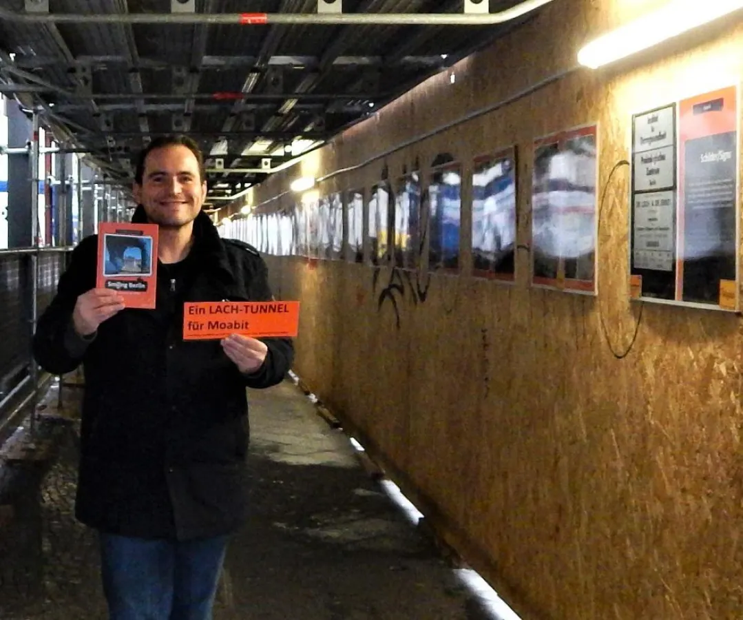 Lasse Walter mit Buch Smiling Berlin in der Ausstellung im Tunnel