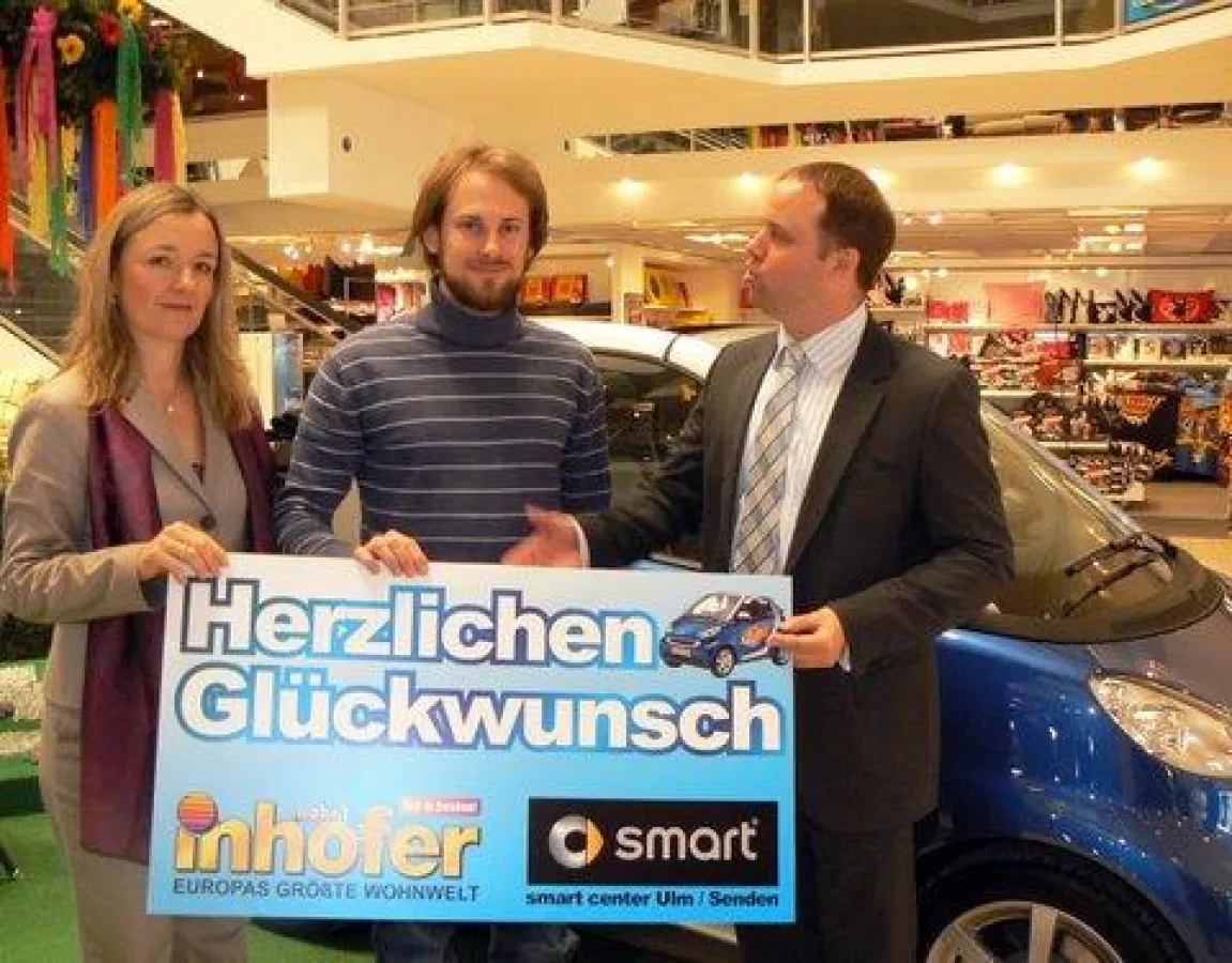 Melanie Inhofer und Dr. Peter Schorr (re.) übergaben Johannes Flammer die Schlüssel für den gewonnenen Smart Cabrio.