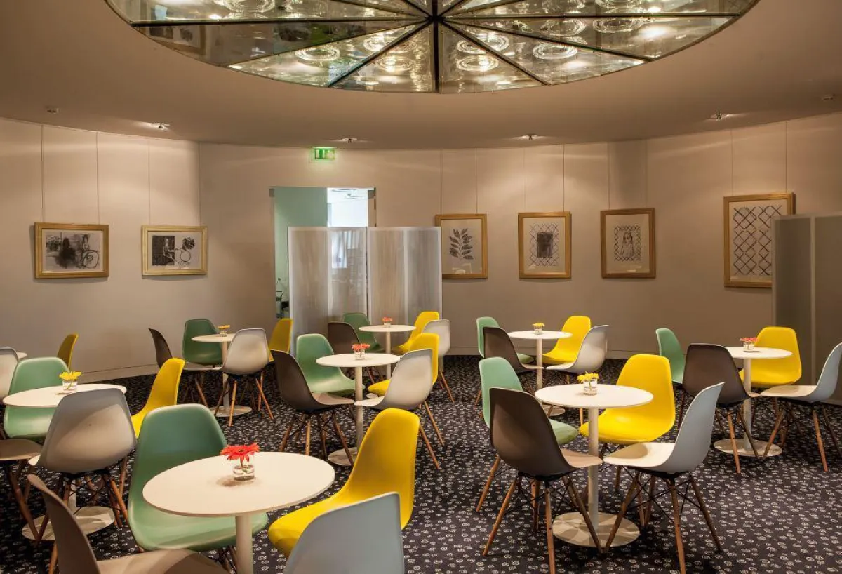 Sommerlich im Style der Sixties: Im Foyer der BGL PNP Paribas stehen farbige DSW-Stühle in Sitzgrupp