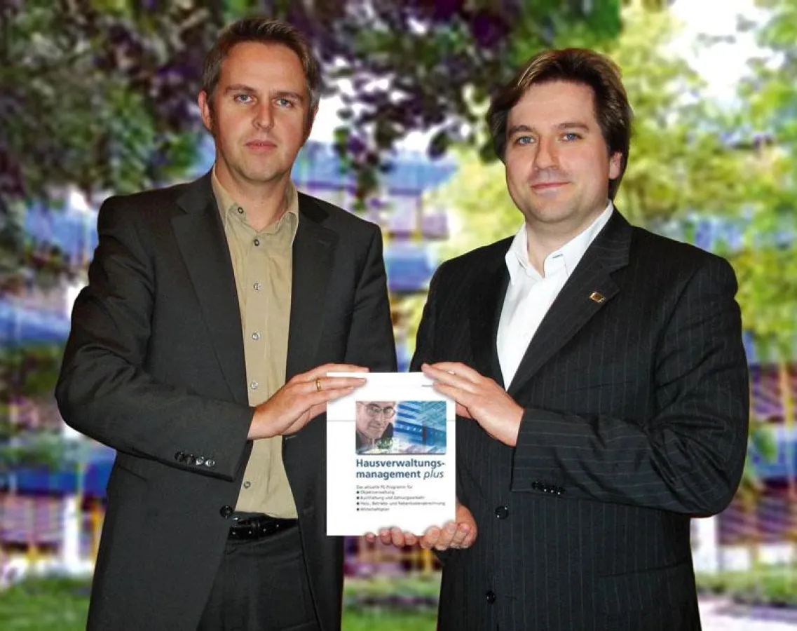 Übernahme: Symbolisch mit einem Software-Paket überreicht WEKA-Geschäftsführer Werner Müller (links) die bisherige hauseigene Immobiliensparte an den neuen Besitzer Matthias Sykosch, Vorstandsboss der