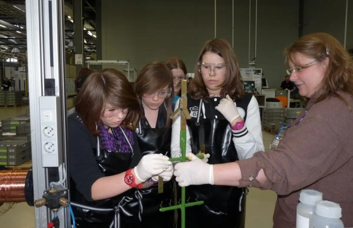 Galvaniseurmeisterin Sonja Tonat (r) erklärt den Schülerinnen die Grundlagen des Galvanisierens.