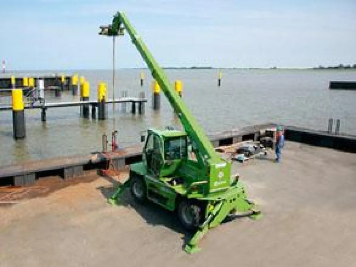 Bildunterschrift: Merlo Roto Teleskopmaschine 38.16 aus dem HKL MIETPARK übernimmt Verladearbeiten beim Bau des neuen Schlepperhaf