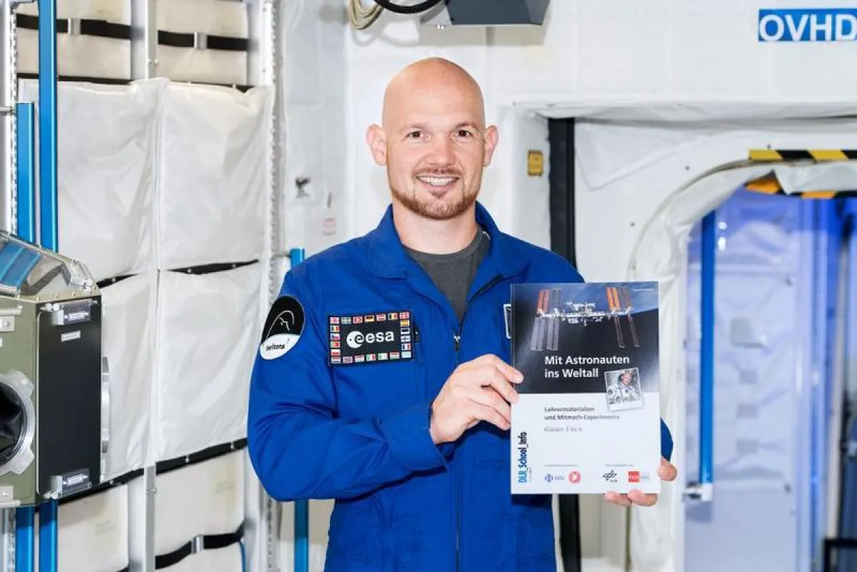Alexander Gerst mit dem Schulheft „Mit Astronauten ins Weltall“.  (© DLR)