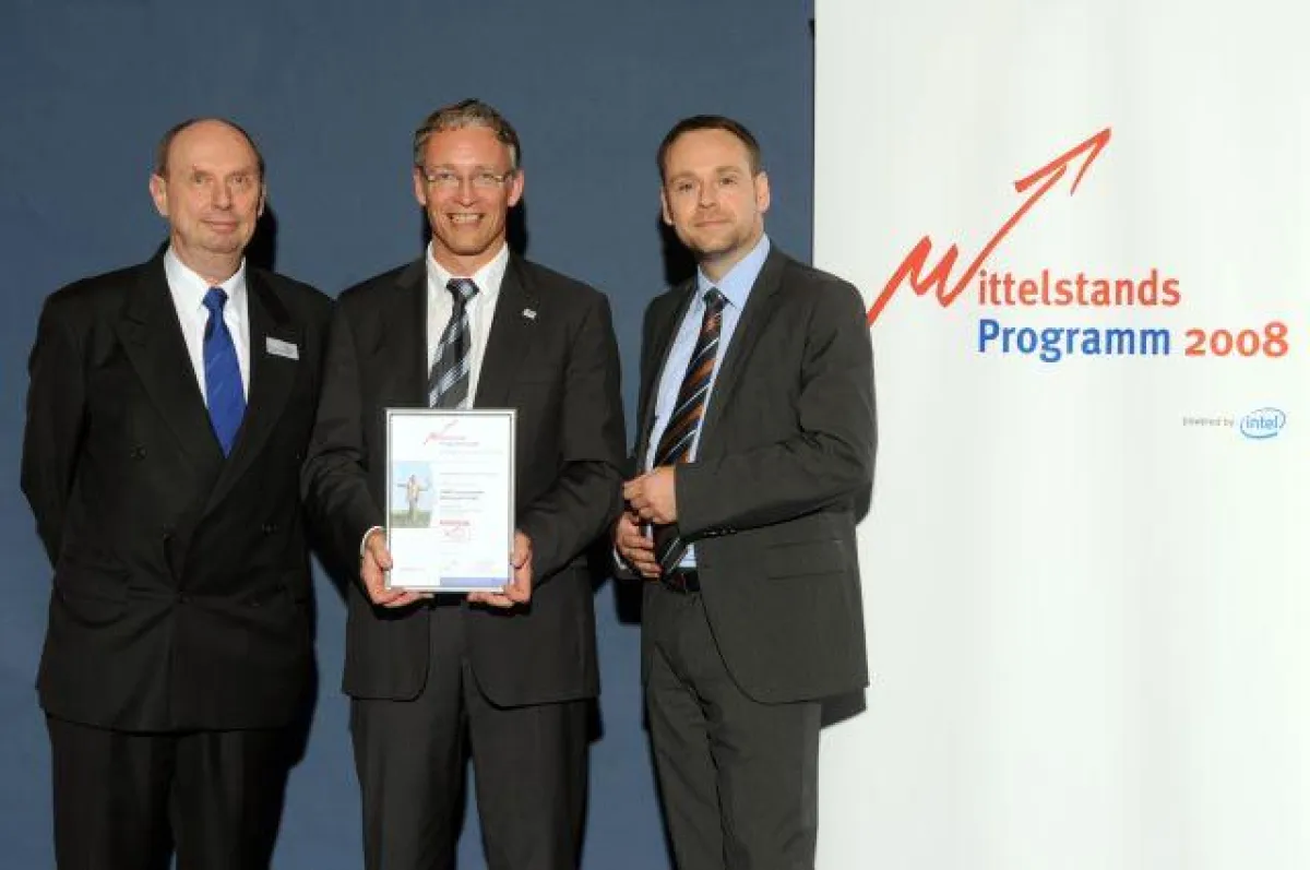 Dr. Karl Schlagenhauf (Innovationsrat) und Sponsor Fred Keßler (InterSalesPro) überreichen Dr. Paul Harten (LIMO) die Sieger-Urkunde