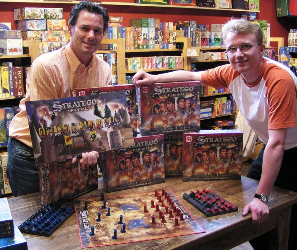 Markus Becker, Marketingleiter von JUMBO Spiele, überreicht Oliver Mueller (Spielexperte beim Spielwarenfachhändler Roskothen in Duisburg) exklusiv die ersten Exemplare des neuen Stratego Original.