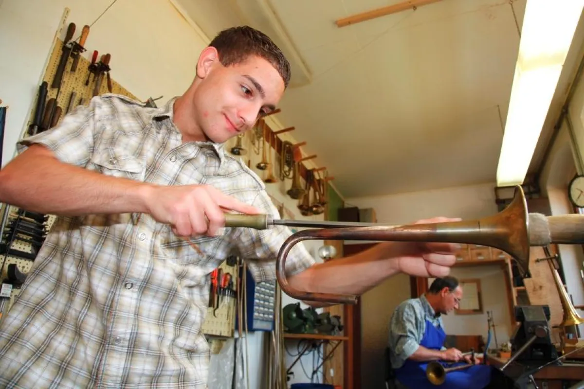 Im Foto vorn der junge Florian Willenberg in der Metallblasinstrumentenwerkstatt seines Vaters Bernhard im vogtländischen Markneuk