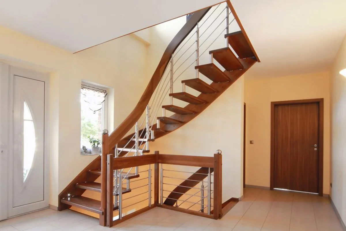 Die Tragbolzentreppe aus Massivholz erstreckt sich über zwei Stockwerke.