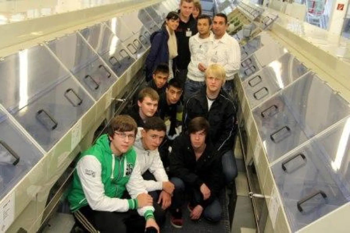 Ausbildungsleiter T. Pulios (1.v.r.) zeigt Schülern die neue Bandanlage.