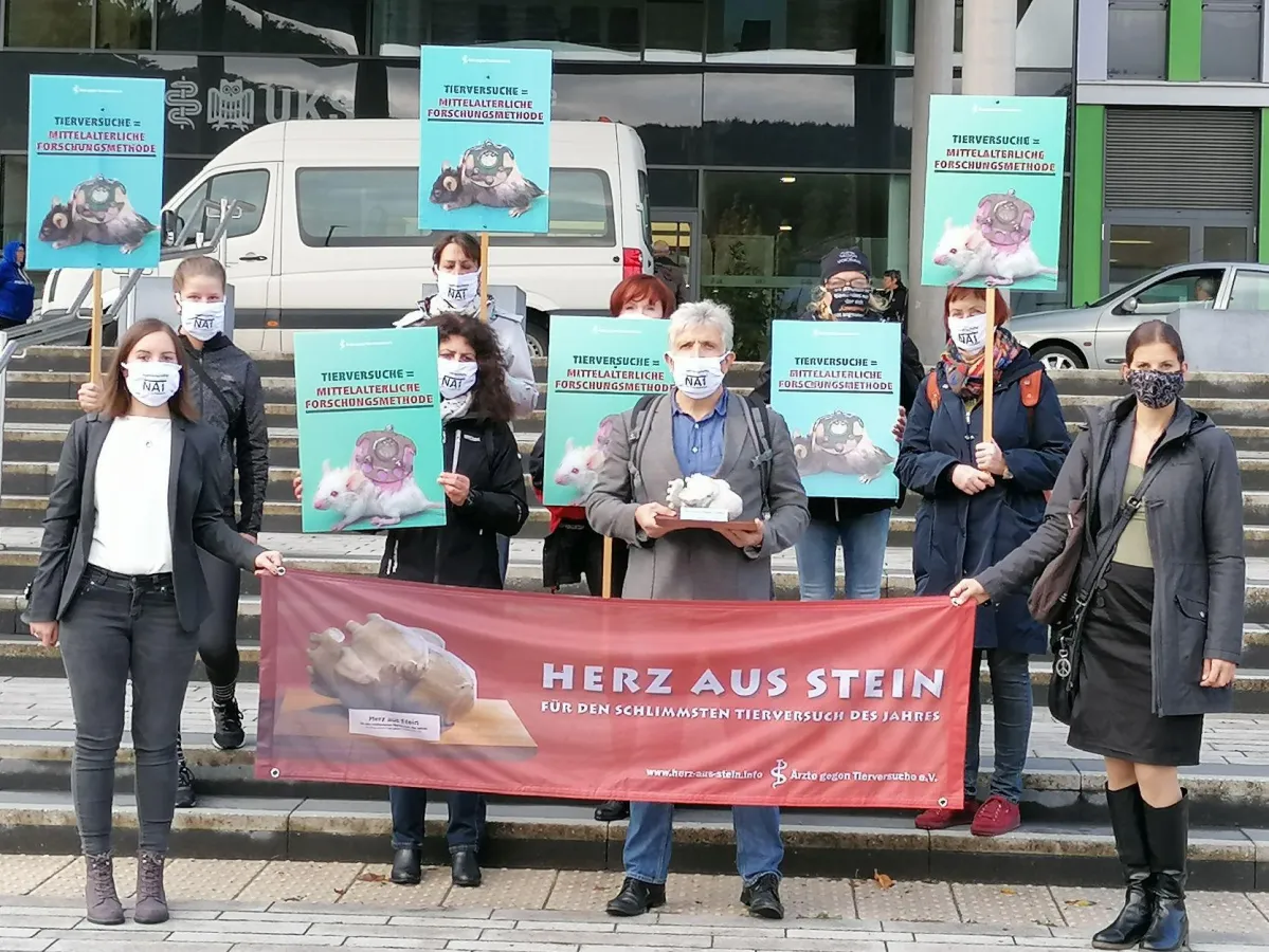 Die Delegation der Ärzte gegen Tierversuche e.V. mit dem Herz aus Stein vor dem Universitätsklinikum
