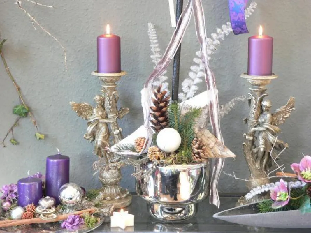 Lilafarbene Stumpenkerzen mit dem RAL-Gütezeichen bringen silberfarbene Weihnachtsaccessoires zum Leuchten! Fotovermerk: Gütegemeinschaft Kerzen Deko: www.gaertnerei-friedrichs.de