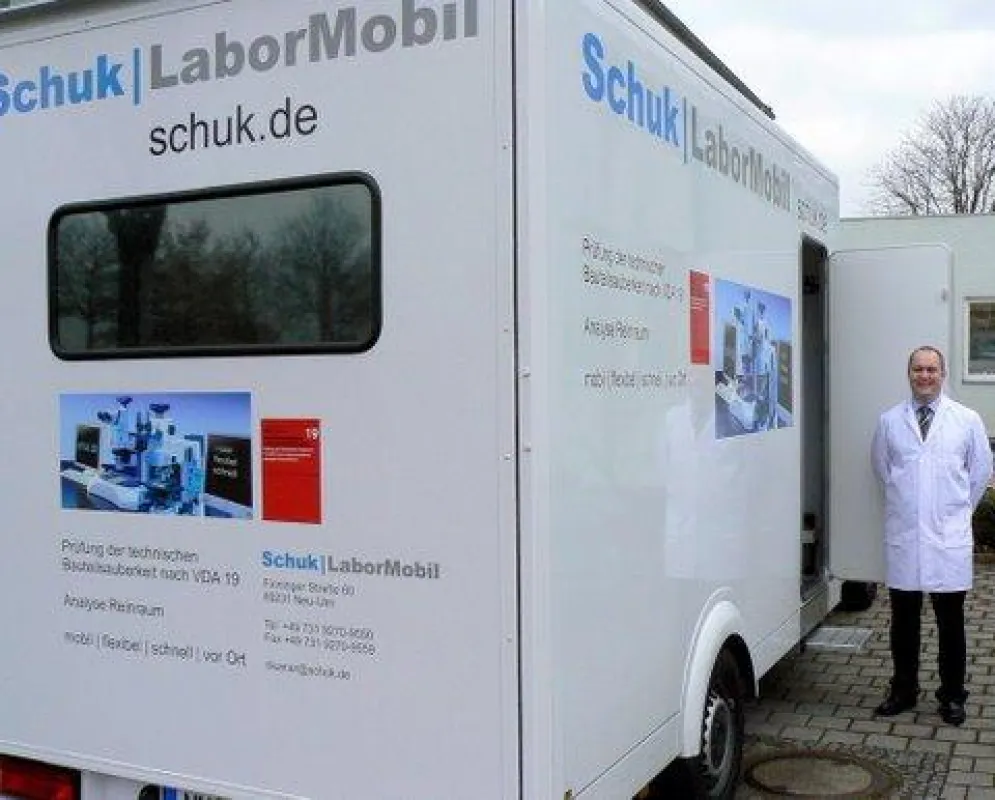 Jörg Schneider, Techniker der Schuk GmbH, vor und im Labormobil, in dem Bauteile auf ihre Sauberkeit im Mikrobereich geprüft werden. Foto: up
