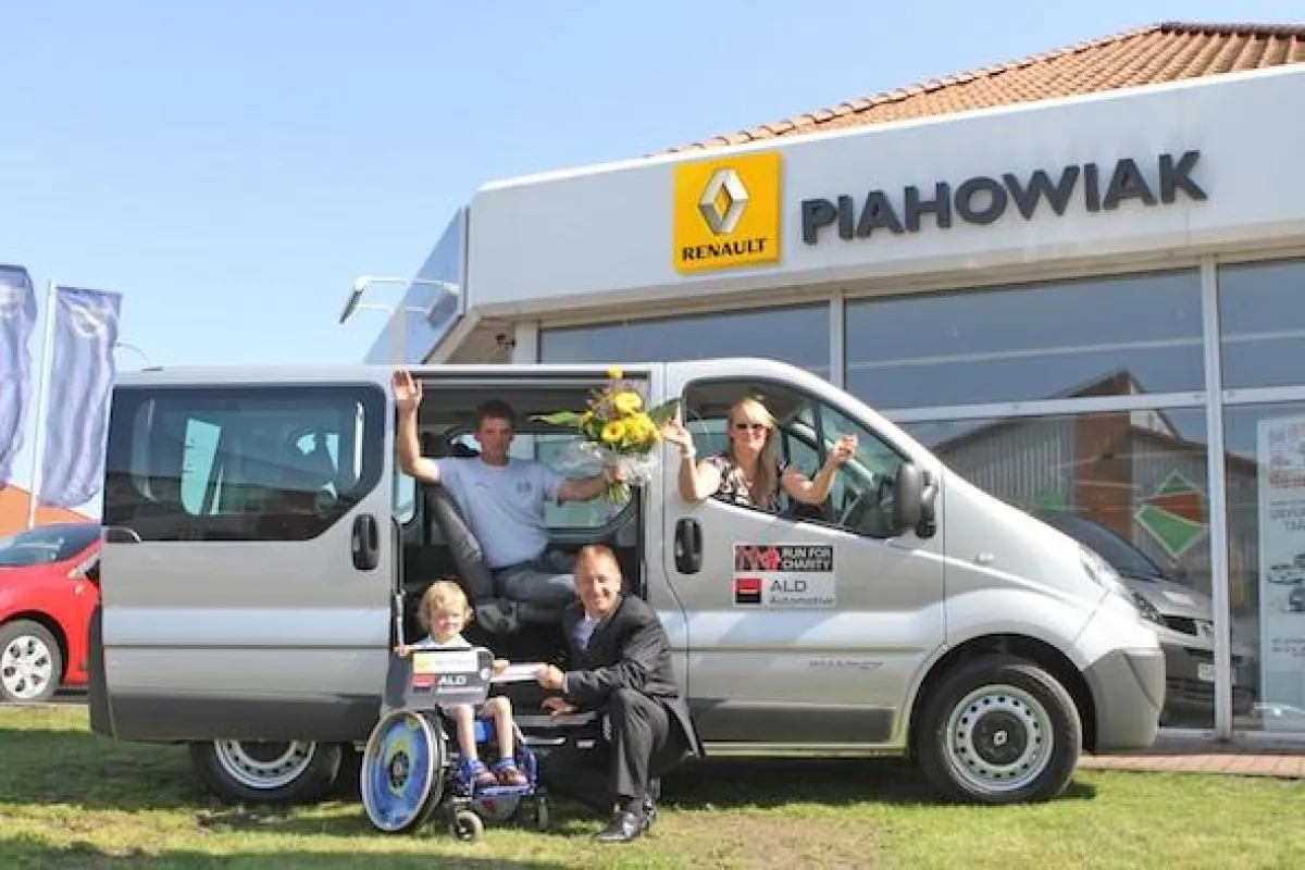 Noah Jaskulke und Karsten Rösel (Geschäftsführer der ALD AutoLeasing D GmbH) vor dem Auto, Thomas und Britt Jaskulke im Auto