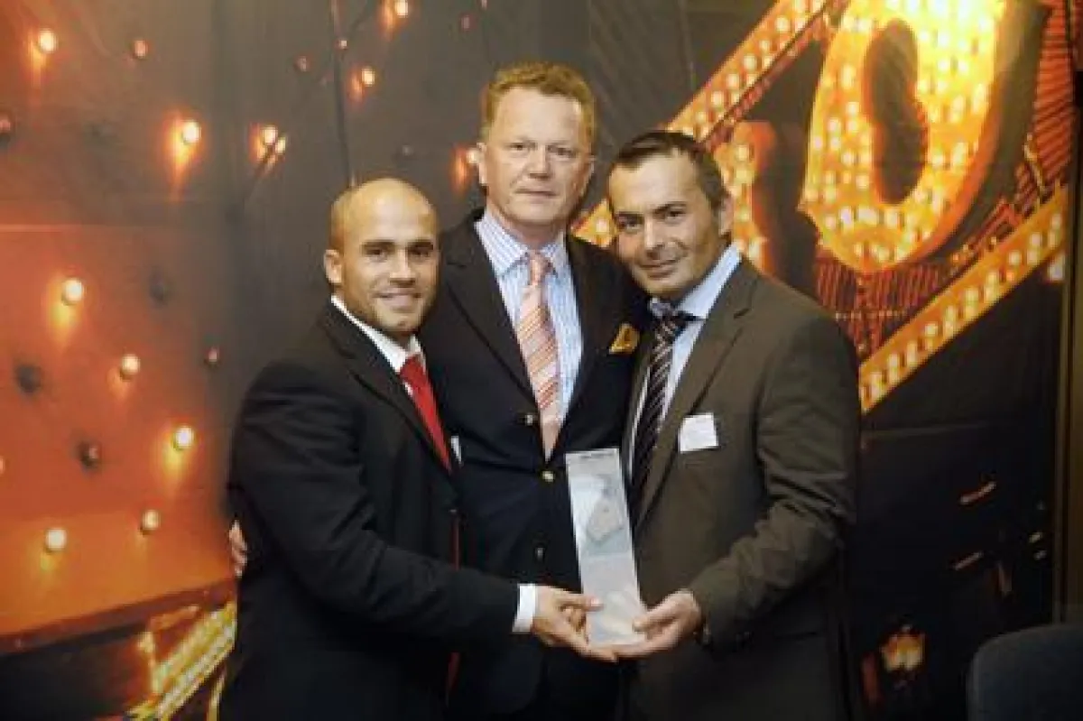 (FOTO: DIE WELLE, Frankfurt am Main) Gastgeber Heinz-Rudi Krämer, Asset Manager der WELLE, überreicht Tarkan Straub (rechts) und Floreal Pedrazo von Cushman & Wakefield die begehrte Broker Poker Troph