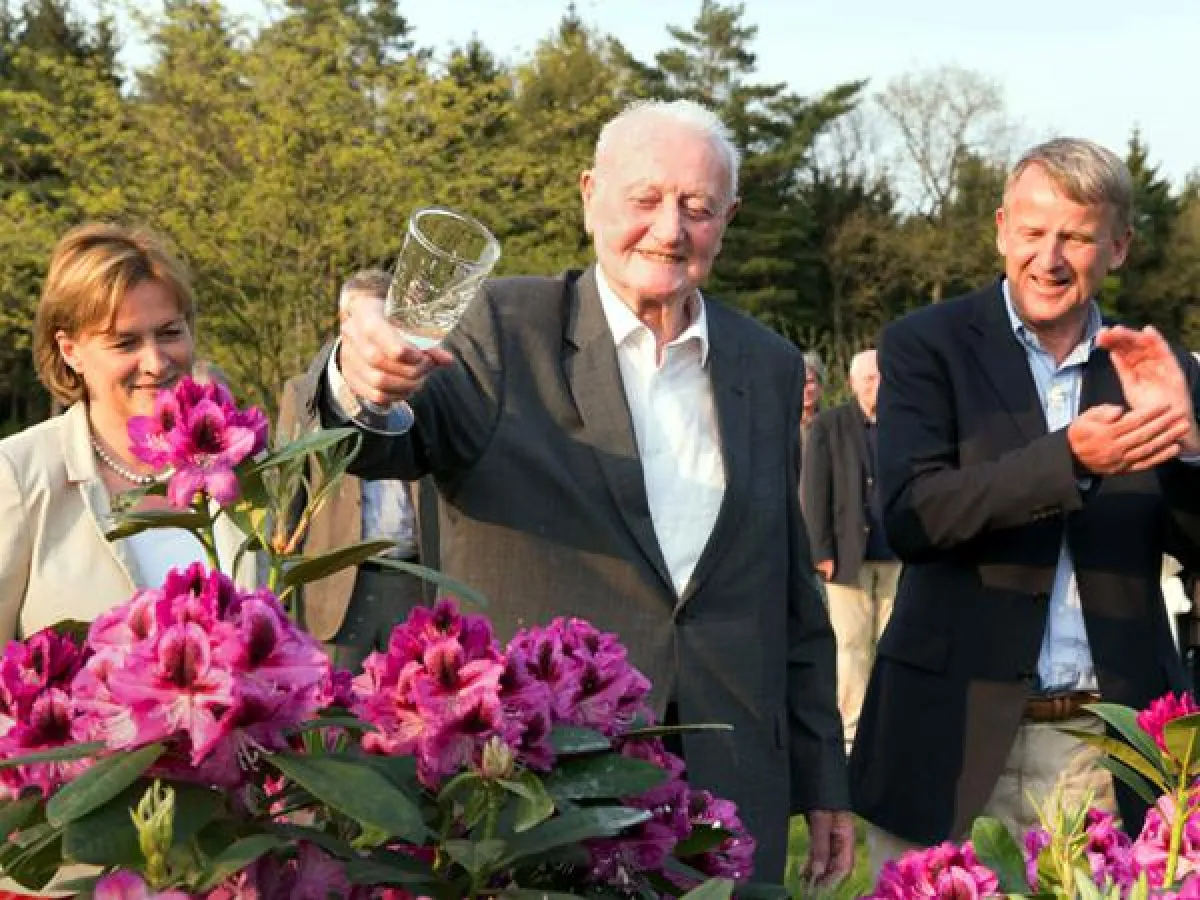 „Tullum“ tauft Tullum – Rolf Trauernicht (Mitte) bei der Taufe seiner Rhododendronzüchtung mit Maria