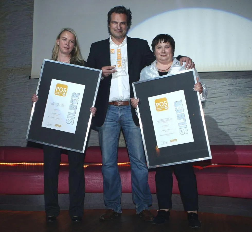 Nahmen den silbernen POS-Marketing Award in Empfang: Annette Reusch (links) und Lydia Kroll von der Sparda-Bank West gemeinsam mit Michael Hasselbusch, Creative Director der kogag.