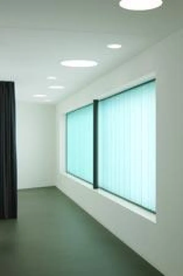 Die transluzente Glaskonstruktion stellt einen farblichen Kontrast zur Fassade dar