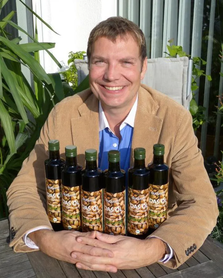 Dr. Christof Roscher hält die ersten Flaschen seines neuen Bio-Hanföls duówell® DAS ÖL in Händen