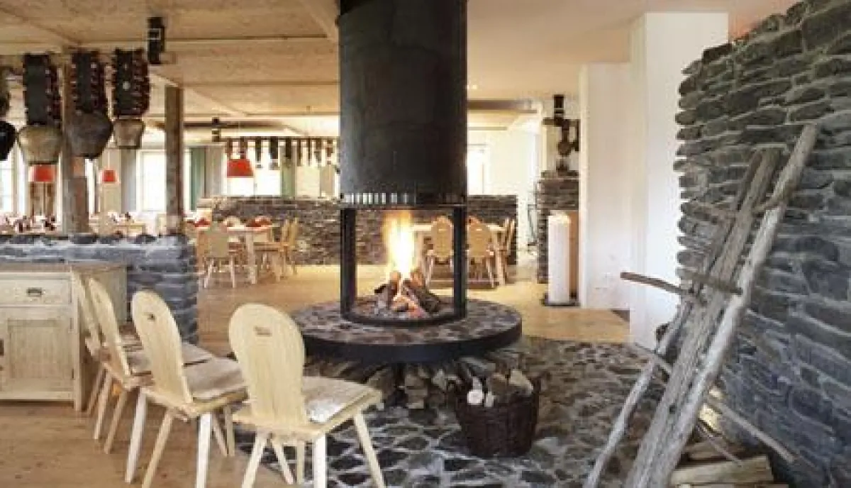 Blick ins Restaurant mit Feuerstelle.