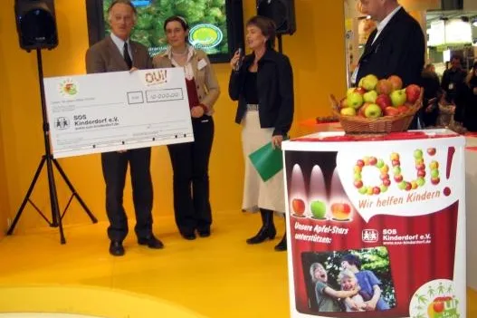 Bild: „Le Crunch“-Äpfel aus Frankreich unterstützen SOS-Kinderdorf e.V. mit einem 10.000 €-Spendenscheck