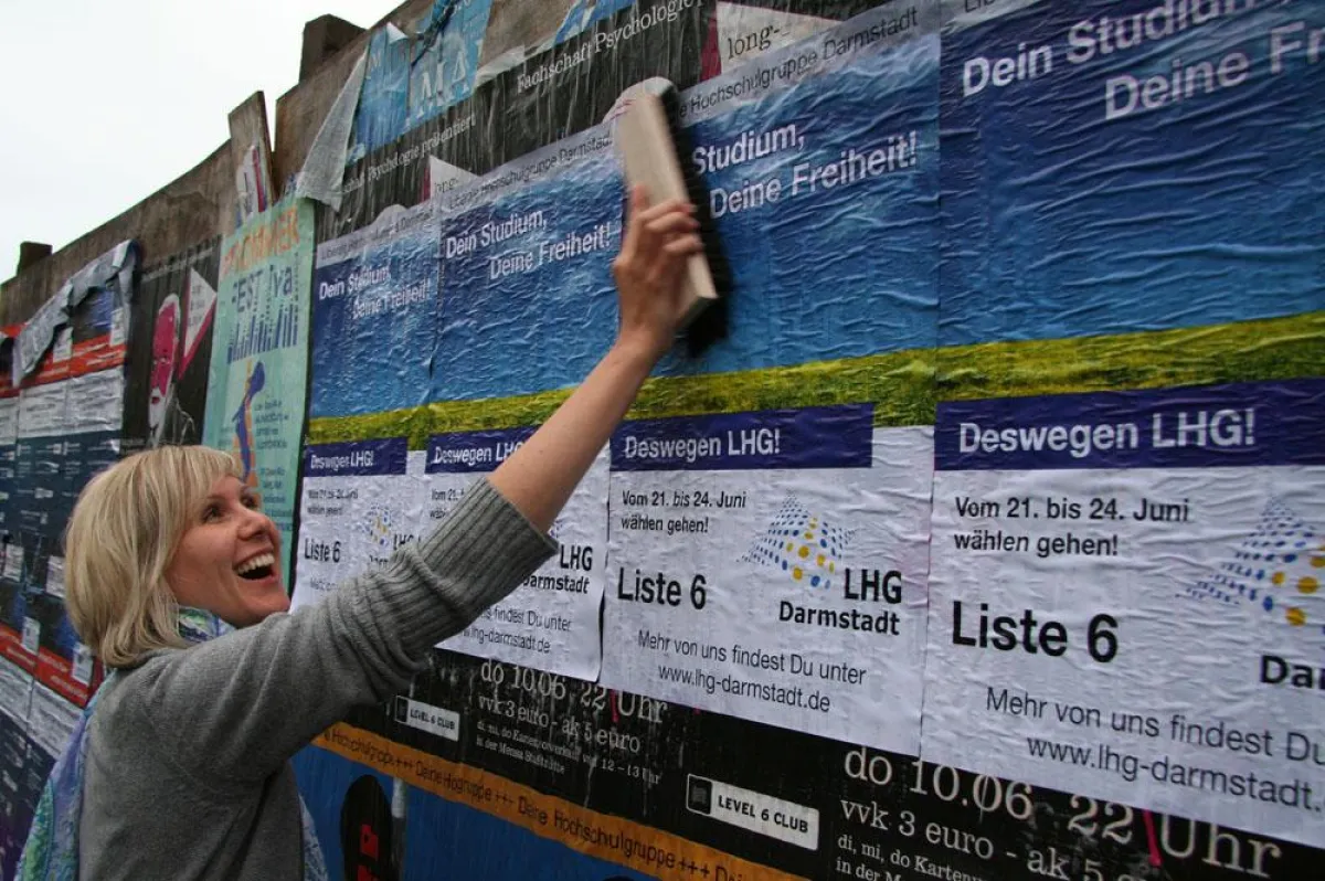 Jana Behrend von der LHG Darmstadt klebt Wahlplakate